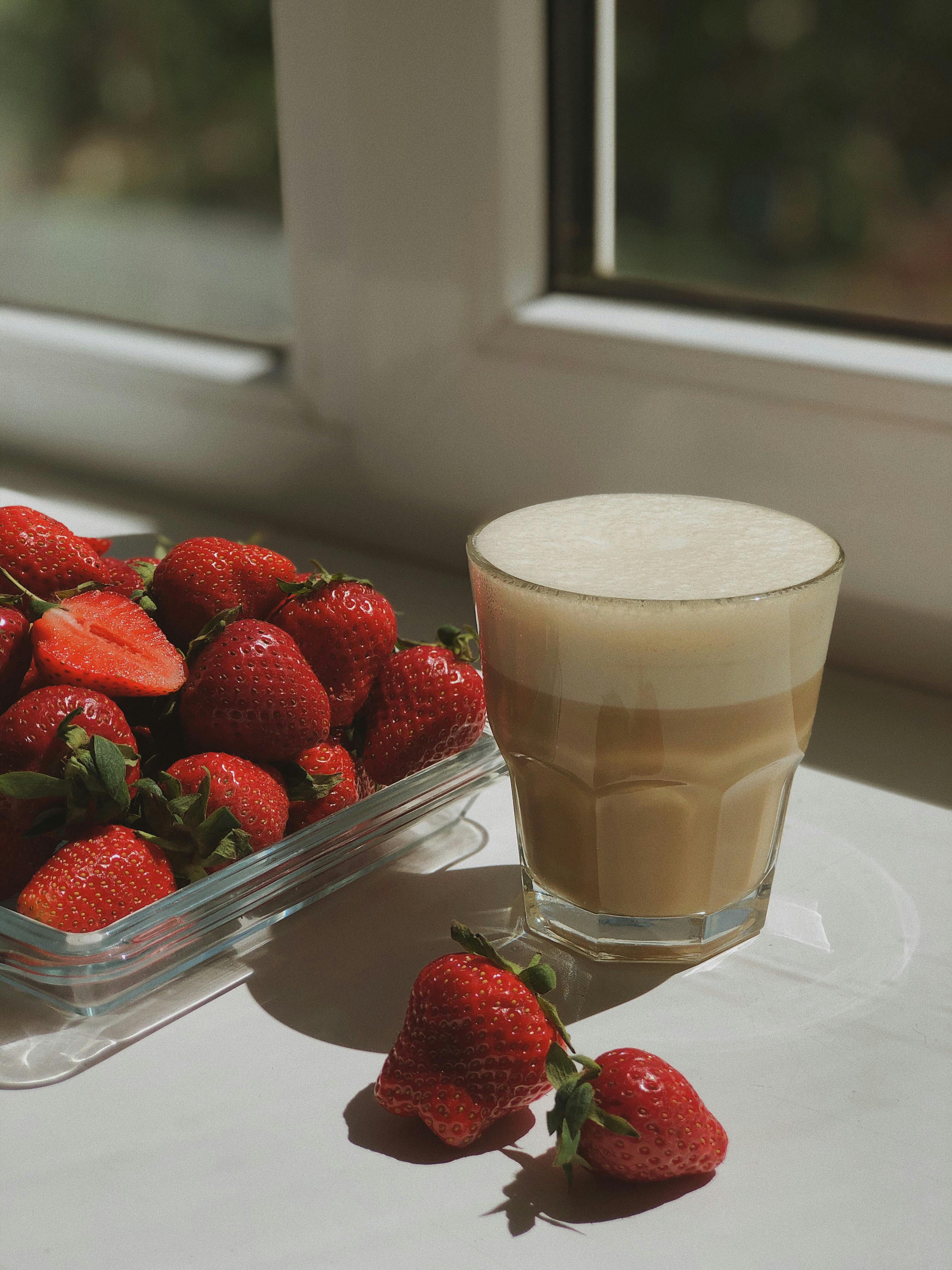 strawberry and white coffee on clear drinking glass