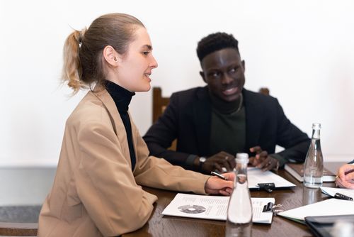 Free Professional team engaged in a business meeting with documents and discussions indoors. Stock Photo