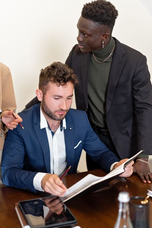 Free Two professionals discussing documents during a business meeting in an office setting. Stock Photo