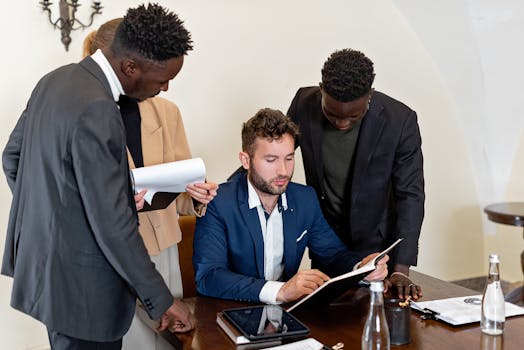 A diverse team collaborating in an office meeting, focusing on documents and teamwork.
