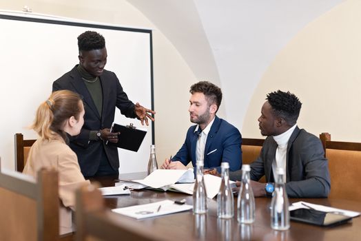 Multicultural team having a discussion in a modern conference room setting.
