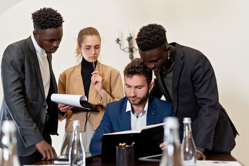 Free A diverse team of professionals collaborating around a table in a modern office setting. Stock Photo