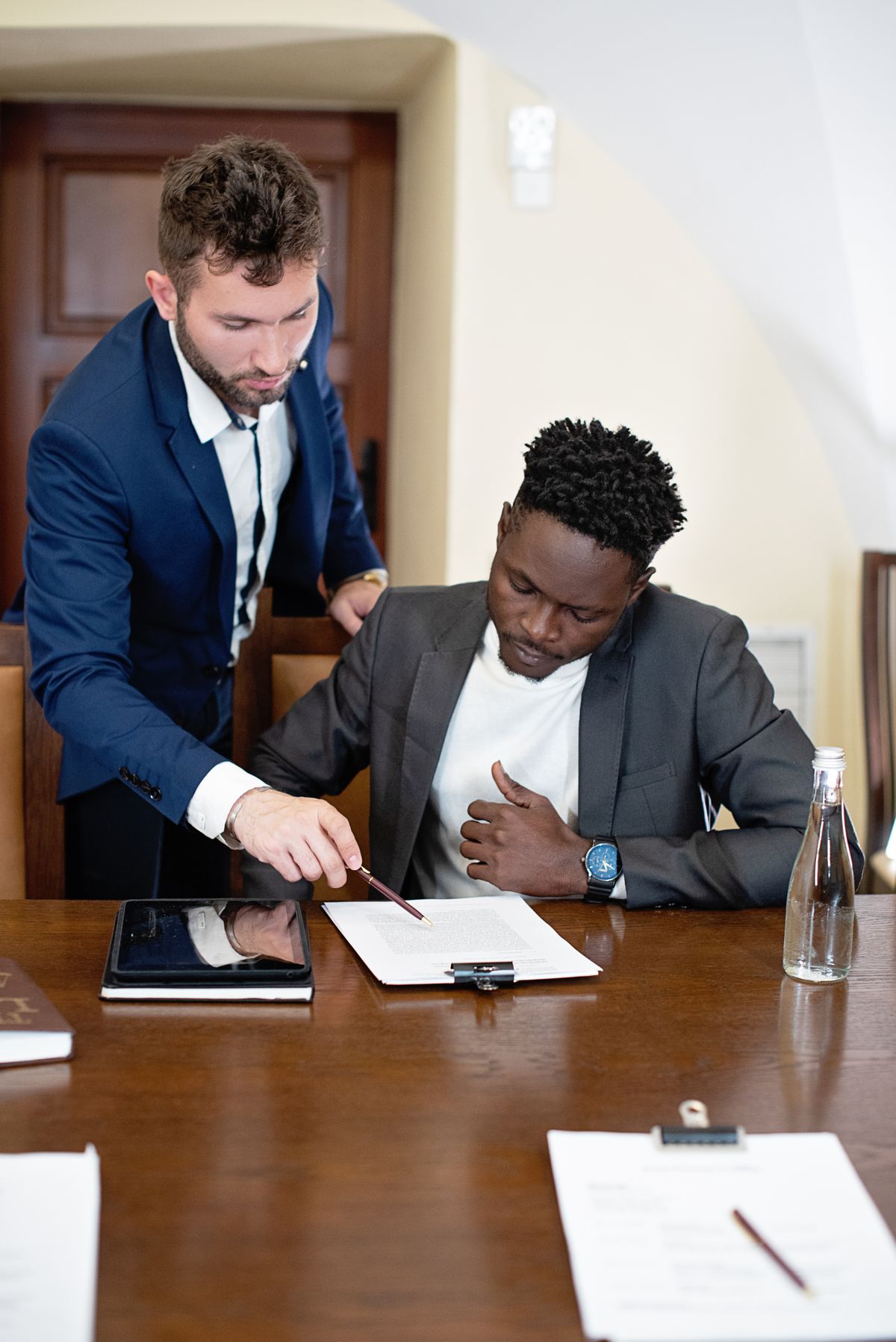 Two business partners working through documents at a table