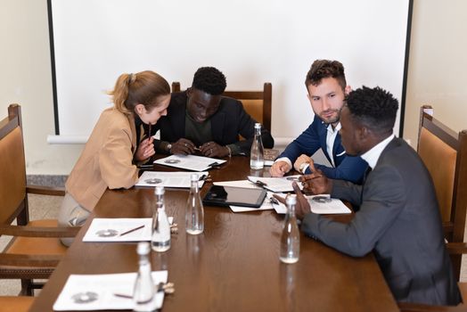 A group of professionals engaged in a collaborative business meeting discussing documents.