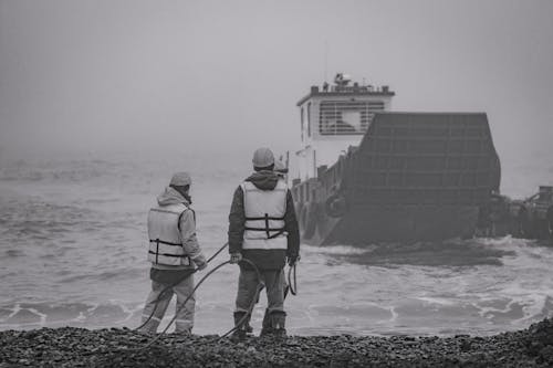 Two Men Standing on the Beach Shore