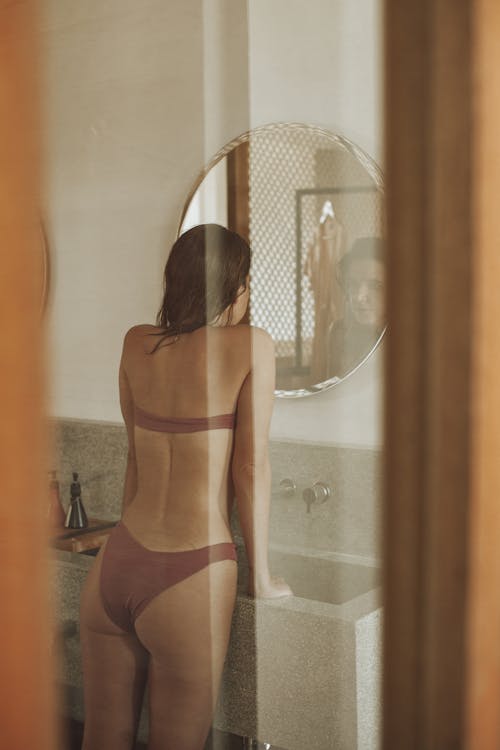 A Sexy Woman in Bikini Looking at the Mirror