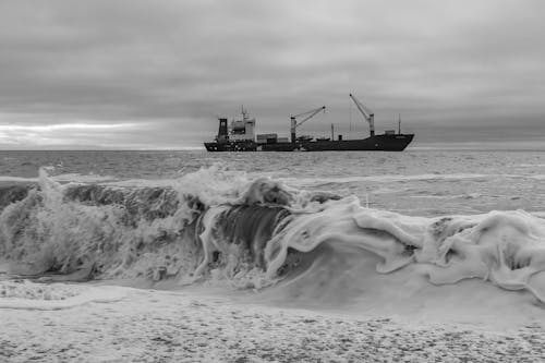 Grayscale Photo of a Cargo Ship on the Sea