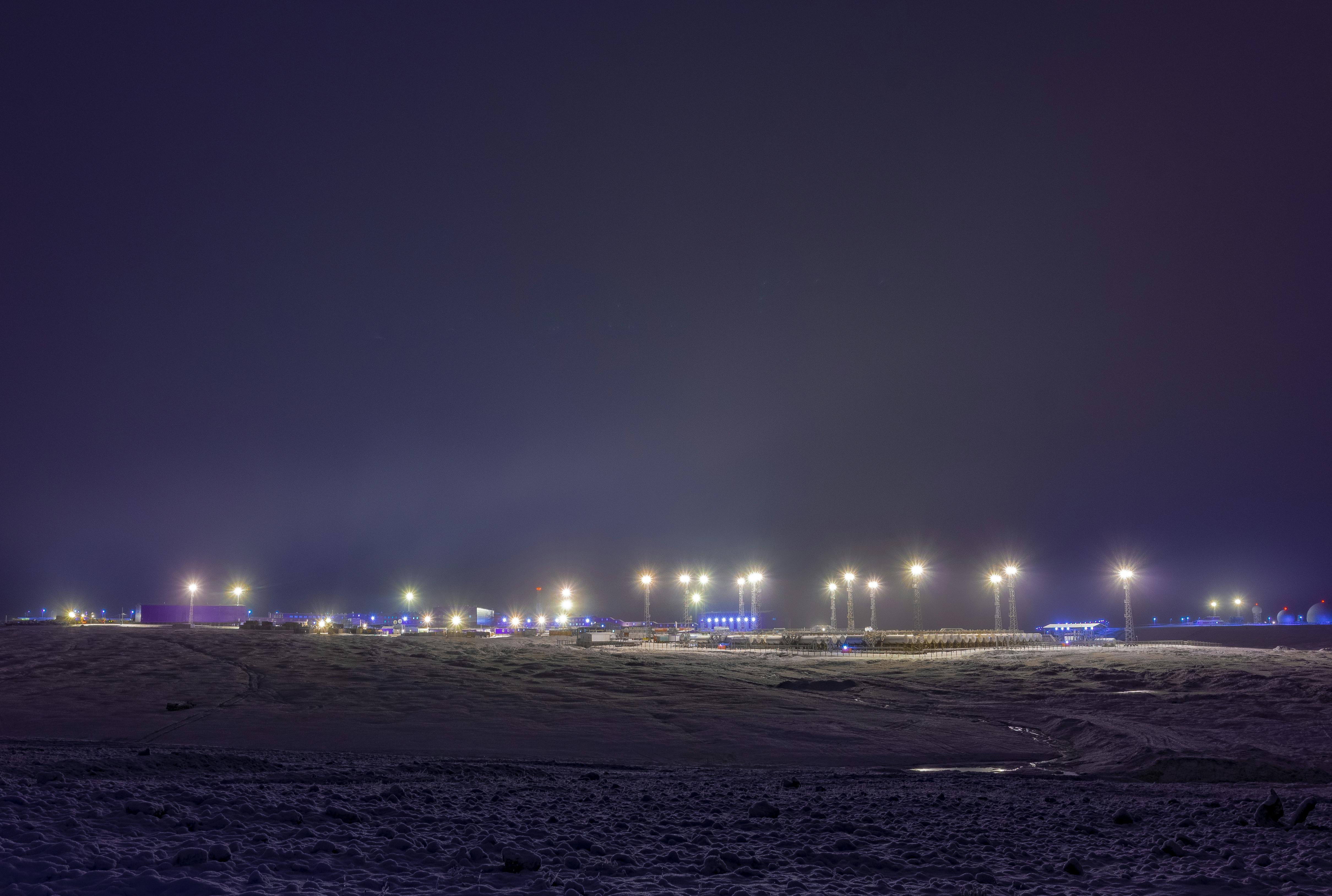 a bare field with lights illuminated at night