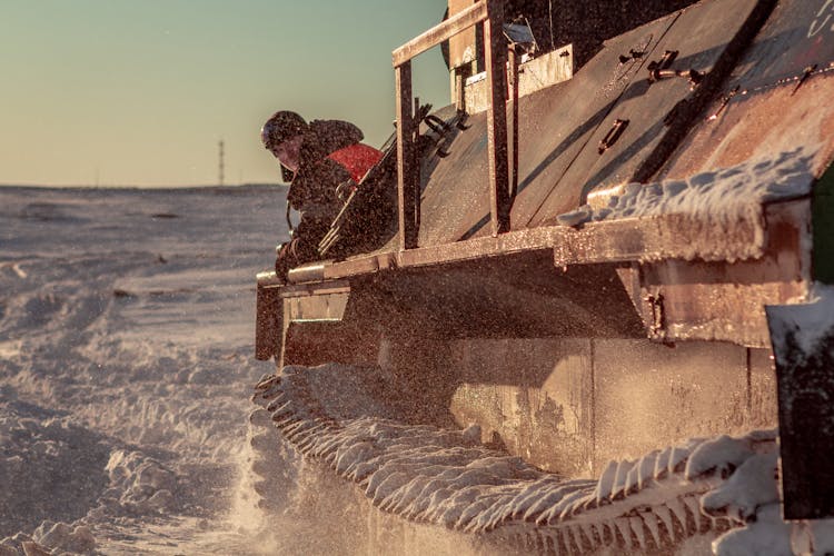 
A Man Operating A Tank On A Snowy Field