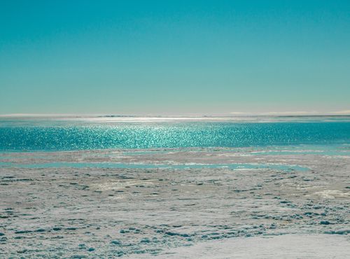 Free Calm winter ocean scene with icy shoreline and clear blue sky. Stock Photo