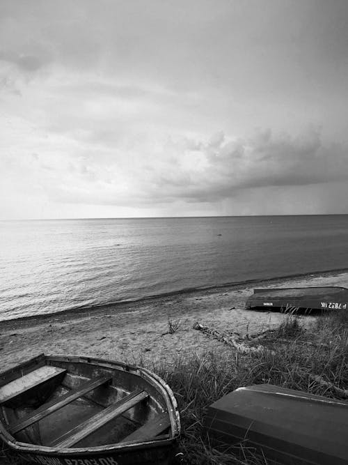 Grayscale Photo of Boats on the Beach 