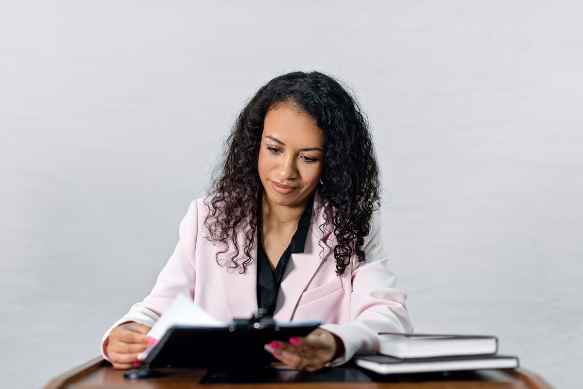 Professionnel en lecture attentive d'un contrat, bureau feutré et concentré
