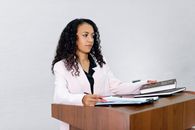 Woman in White Blazer Sitting by the Table