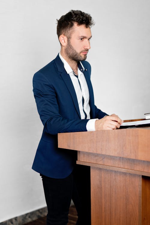 Man in Blue Suit Standing on the Podium