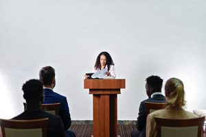 A woman delivering a speech to a conference audience — photo by Mikhail Nilov on Pexels