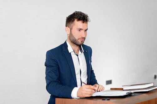 
A Bearded Man in a Blazer Holding a Pen