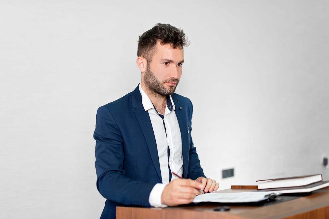 
A Bearded Man in a Blazer Holding a Pen