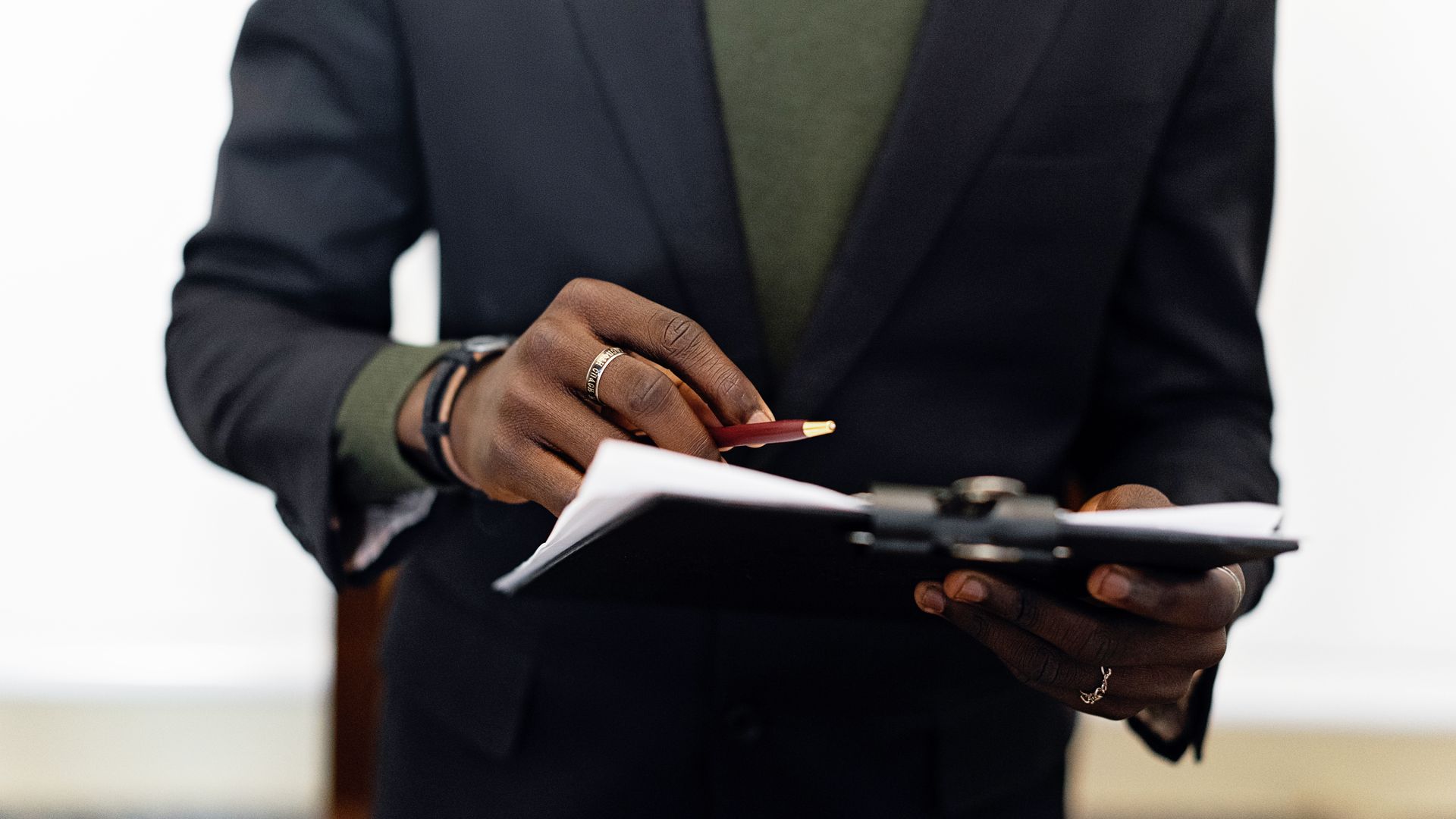 Professional in a blazer holding a clipboard with compliance documents