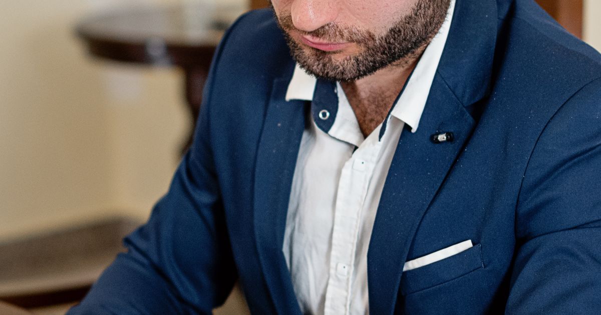 Unternehmer prüft am Schreibtisch die Klauseln eines Rahmenvertrags für Gebäudereinigung