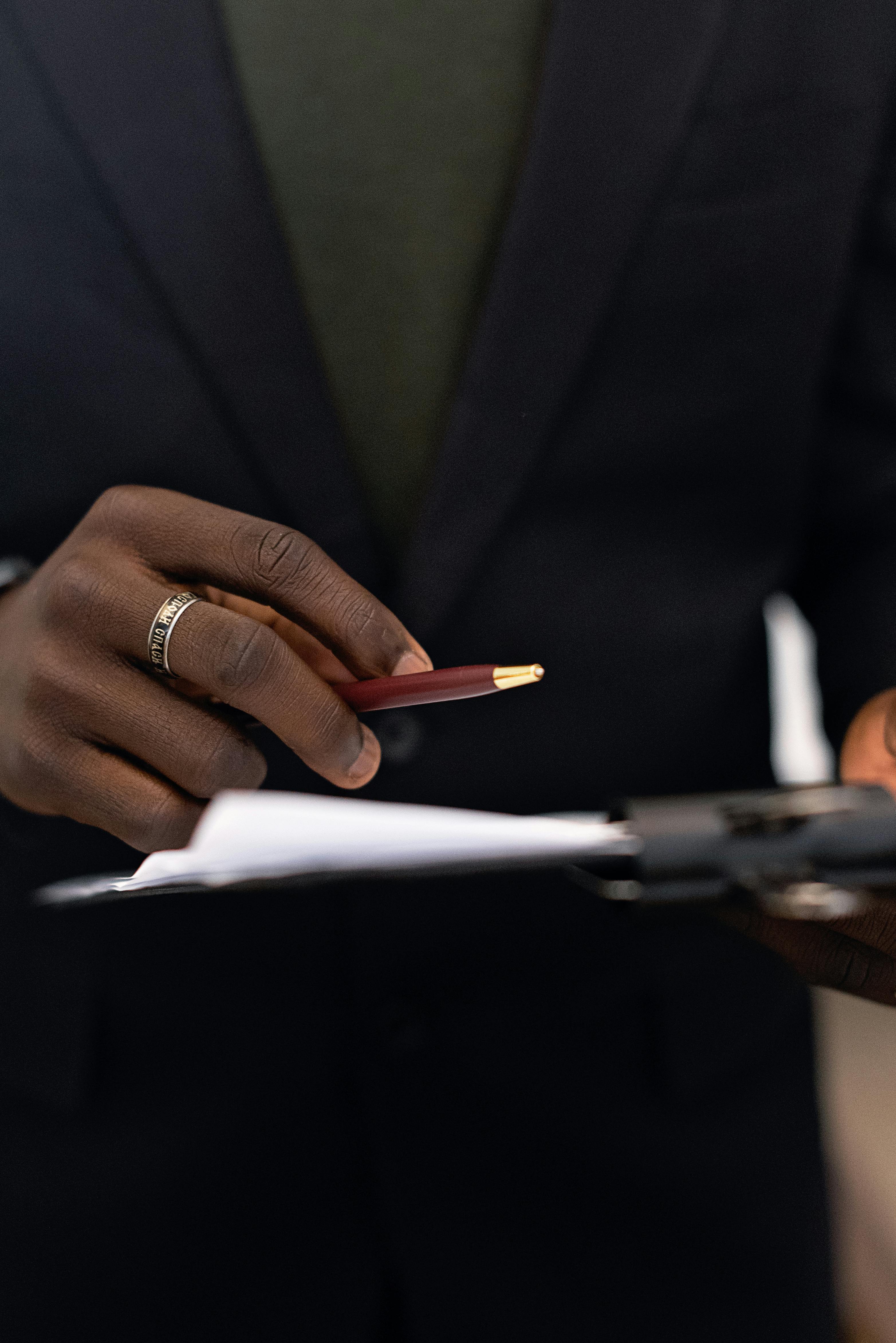 a person holding a pen and a document