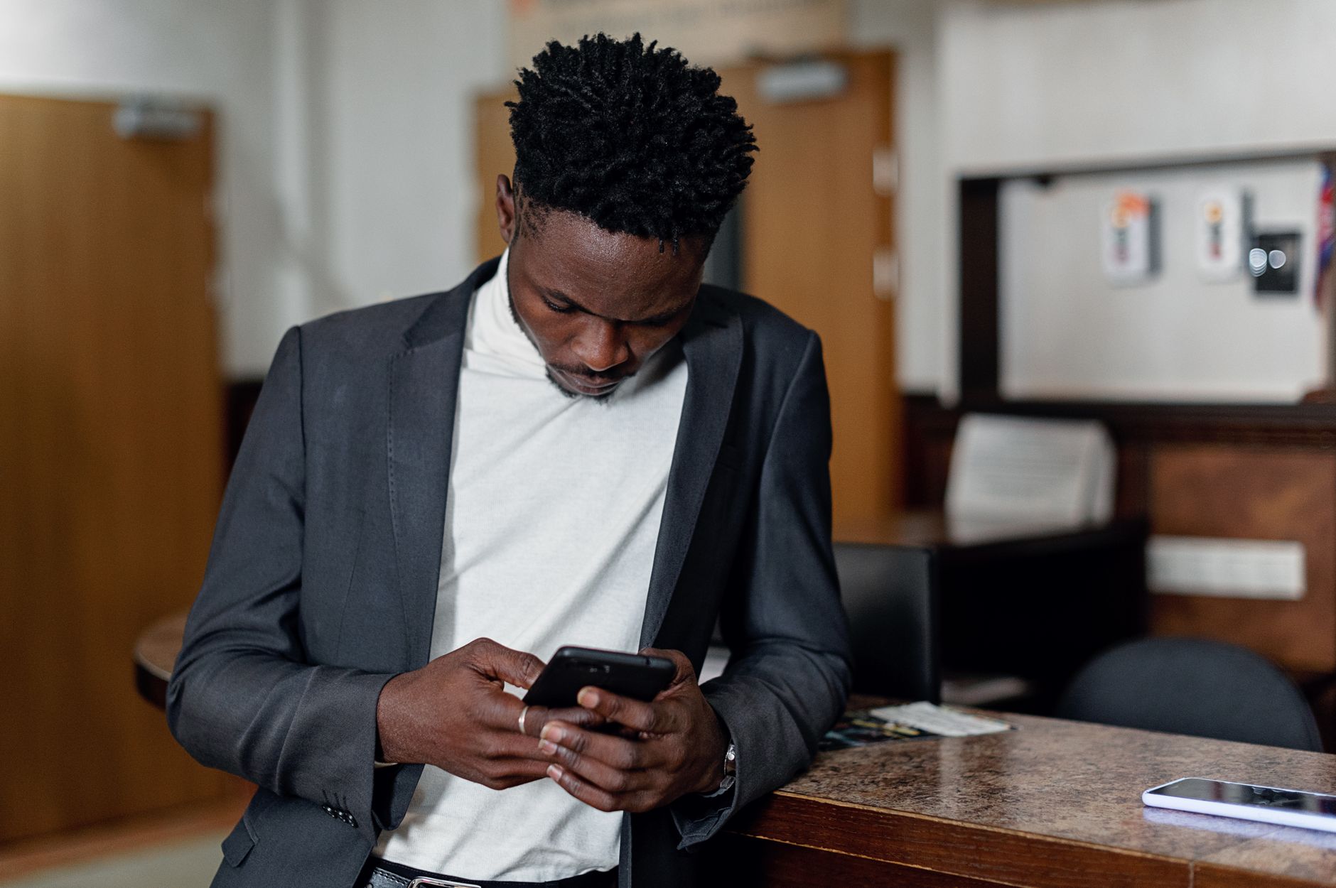 business professional reading emails smartphone office