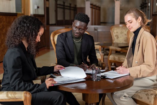 Three business colleagues collaborating and reviewing documents indoors.