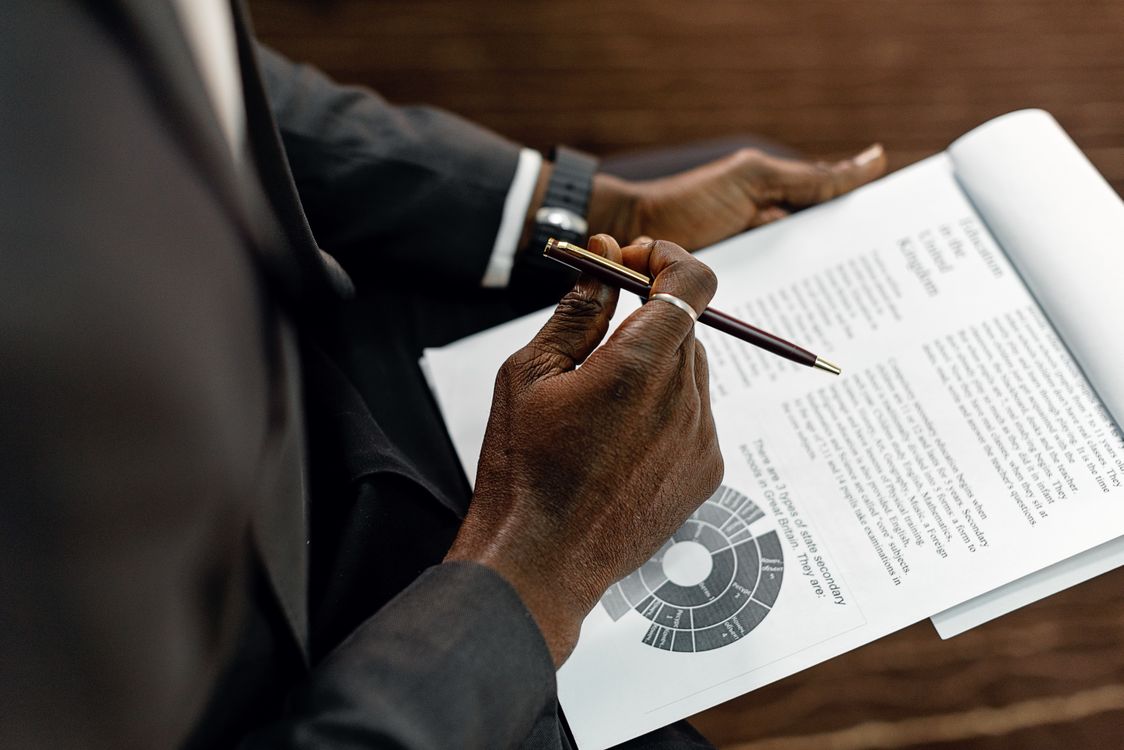 A Person Holding a Document and a Pen · Free Stock Photo