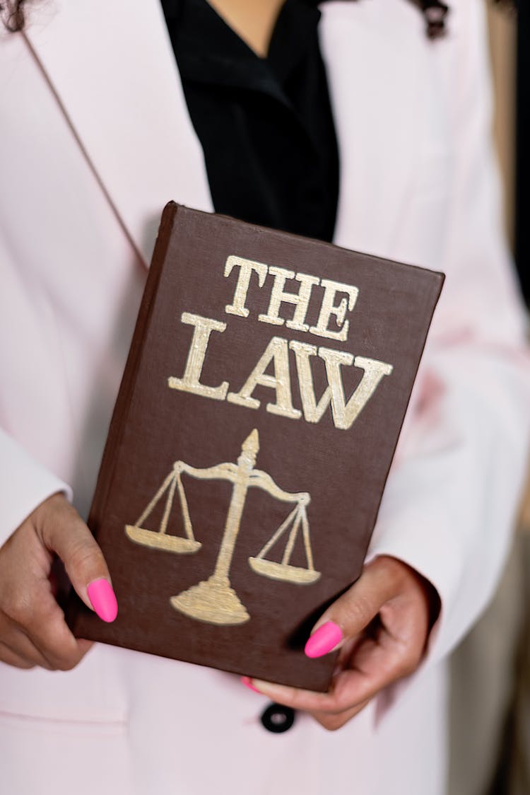 A Person Holding The Law Book