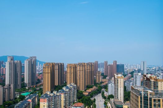 Aerial view of Wuxi cityscape featuring modern skyscrapers under a blue sky.