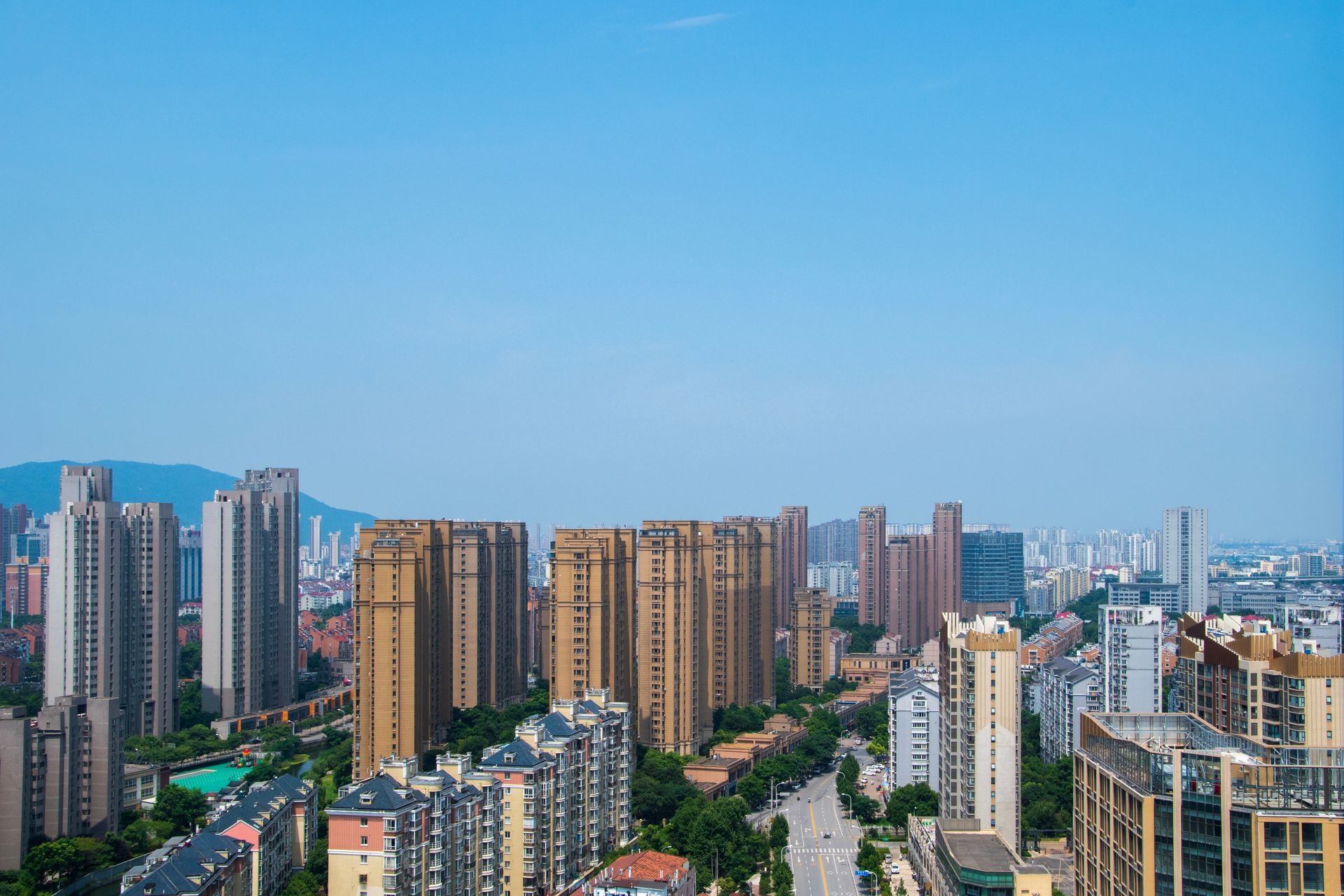 Aerial view of Wuxi cityscape featuring modern skyscrapers under a blue sky.