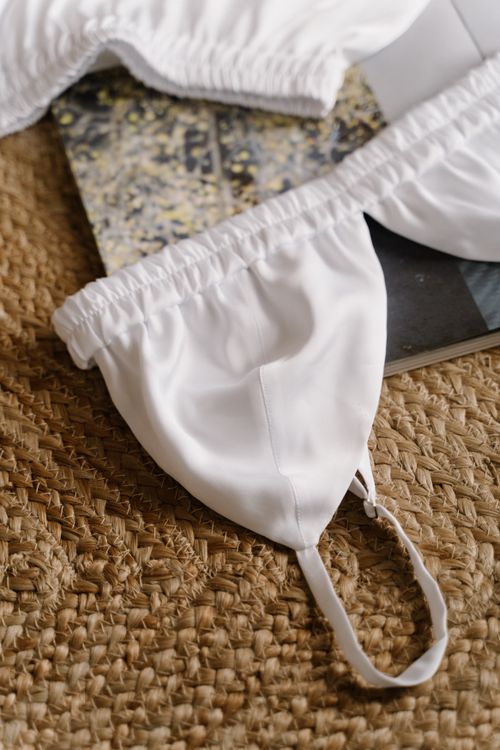 Free Close-up of a white bra on a woven mat surface, offering a chic and stylish look. Perfect for fashion and lifestyle uses. Stock Photo