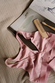 A soft pink bra and accessories laid flat on a bed, creating a cozy vibe.