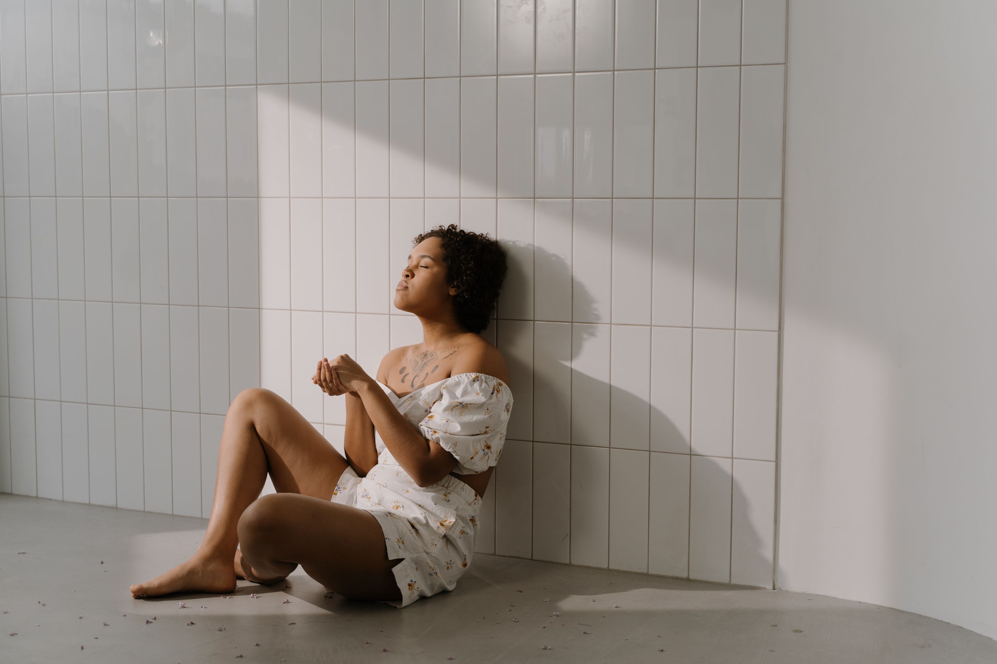 A Woman Sitting on the Floor While Eyes Closed · Free Stock Photo