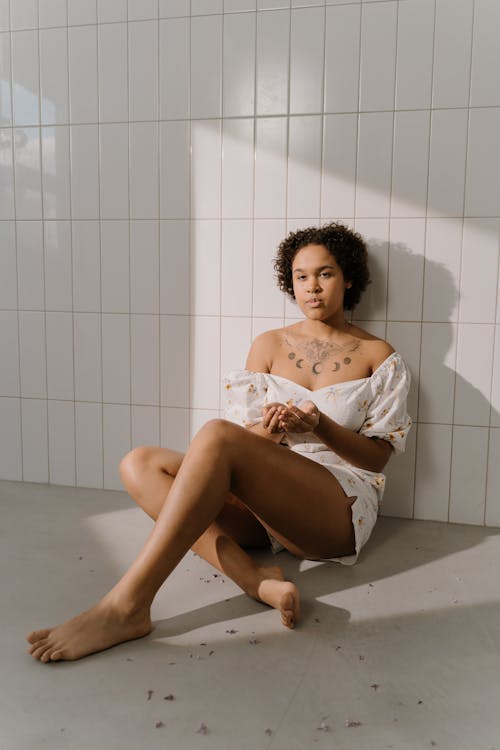 A Tattooed Woman Sitting on the Floor