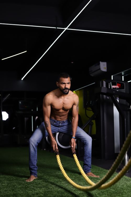 Free A muscular man engages in a battle rope workout indoors, highlighting strength and fitness. Stock Photo