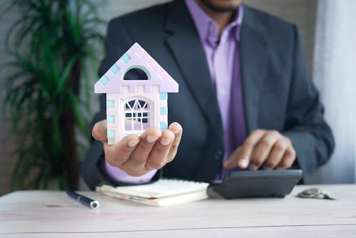 Free A Person Holding a Model House Stock Photo