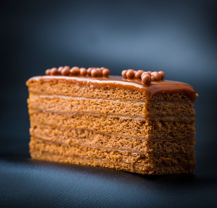 A Slice Of Caramel Cake In Close-up Photography