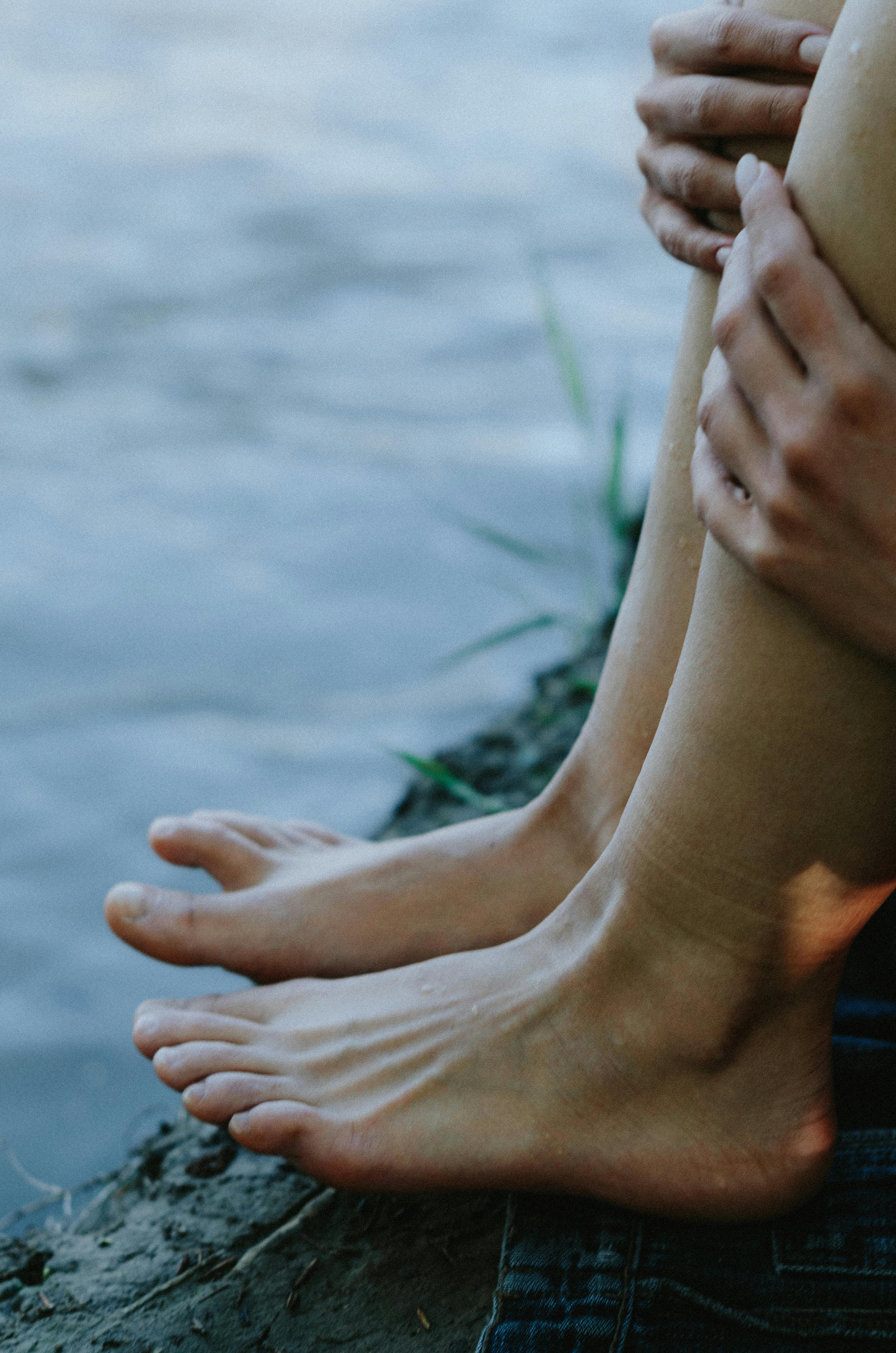 a person s feet on near body of water