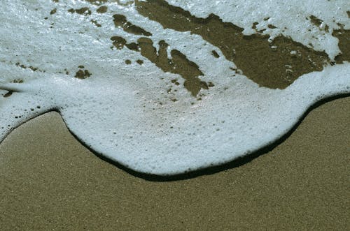 Close-up of Foamy Water Washing Up the Shore 