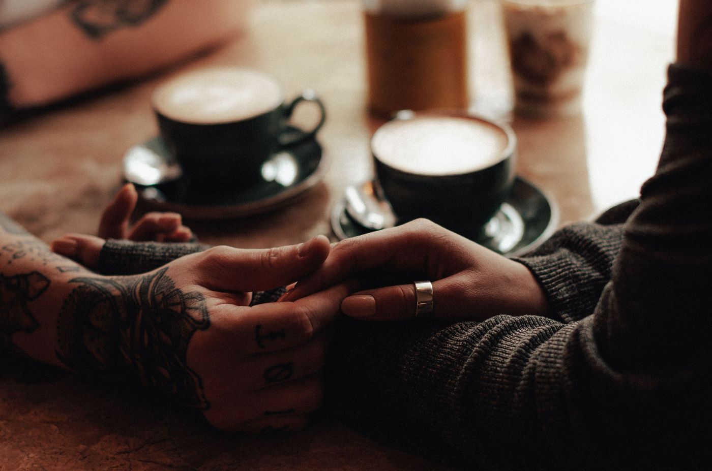 A couple holding hands during a quiet coffee date