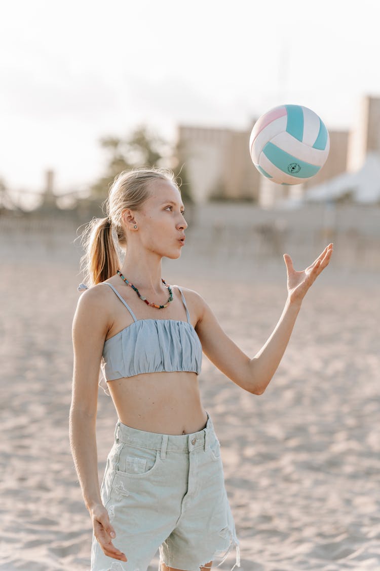 A Woman Playing Volleyball In The Beach