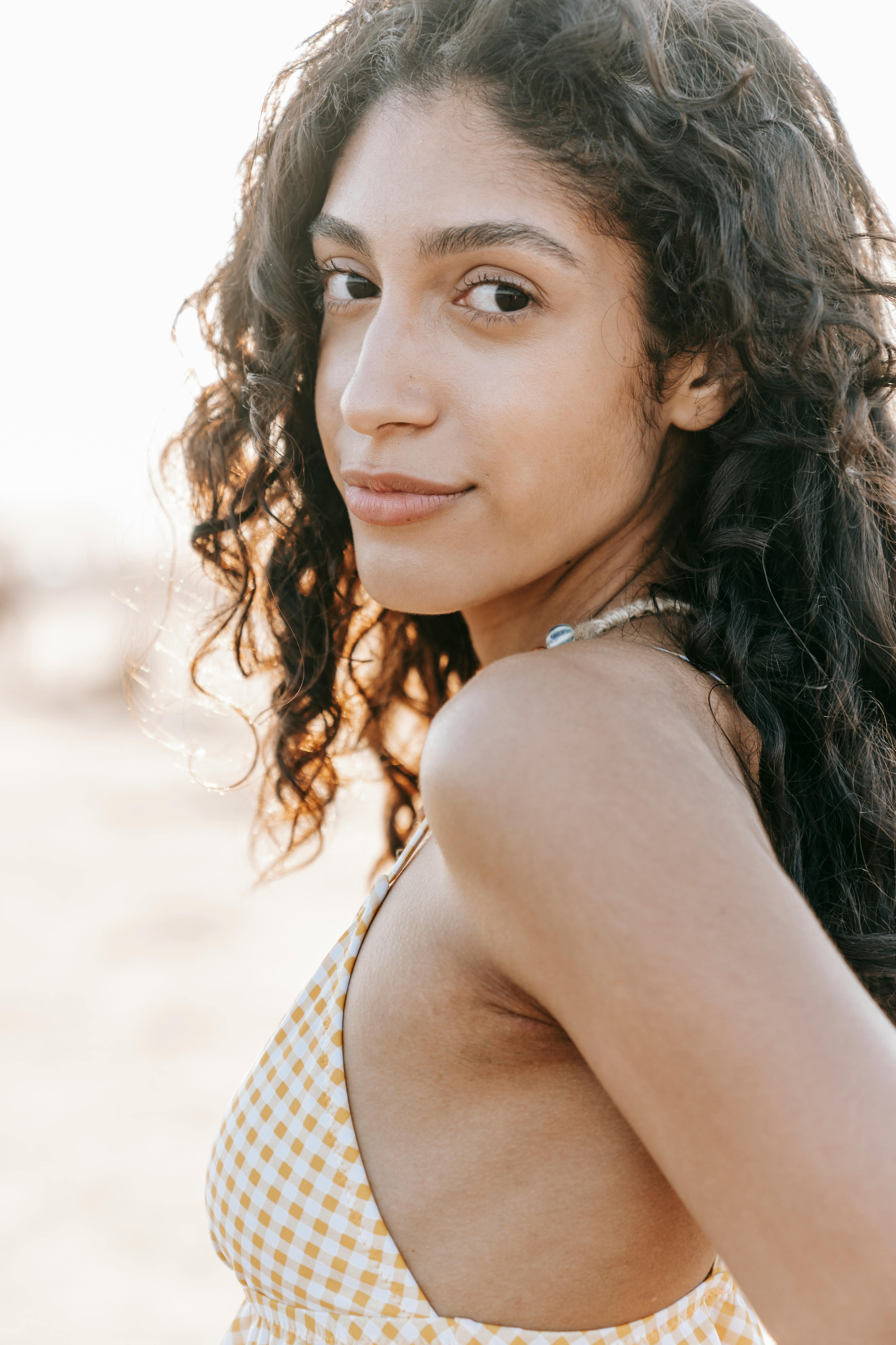 A woman enjoying a serene moment at the beach, showcasing natural beauty and summer vibes.
