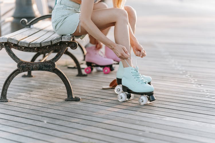 Selective Focus Photo Of A Person Tying Her Roller Skates