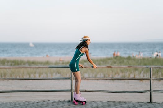 A woman roller skating by a beach promenade on a sunny summer day.