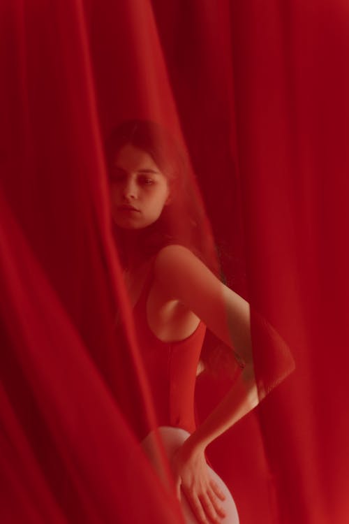 A Woman Posing with Red Curtain