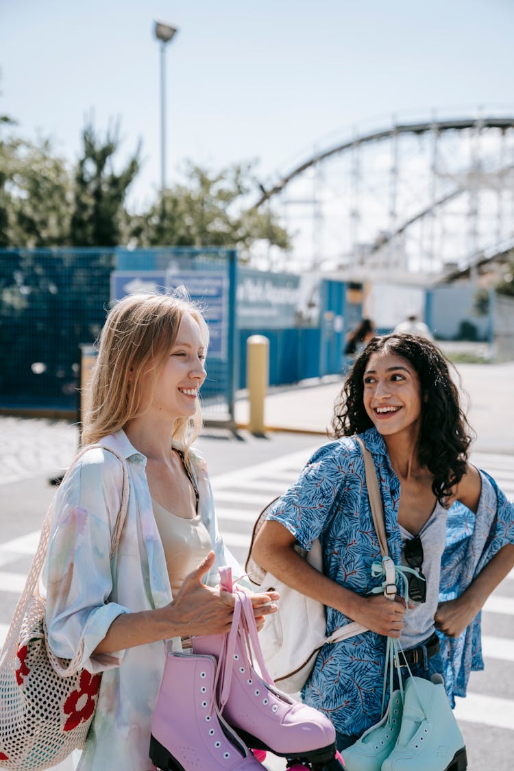 Two Women Carrying A Roller Skates 