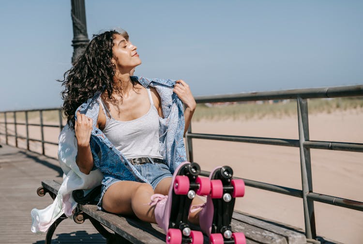 Woman In Tank Top And Button Down Shirt Sitting On A Bench