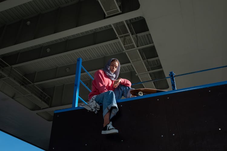 A Woman Sitting On The Edge Of A Ramp