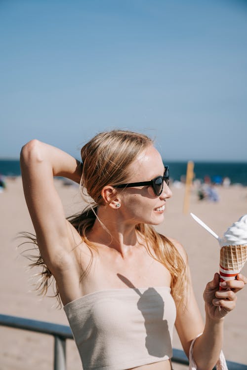 A Woman in a Tube Top Holding an Ice Cream