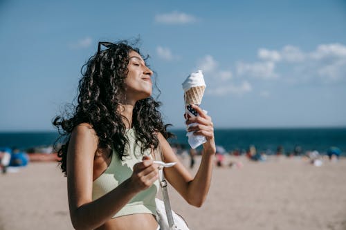 Immagine gratuita di bagnasciuga, capelli ricci, cono di gelato